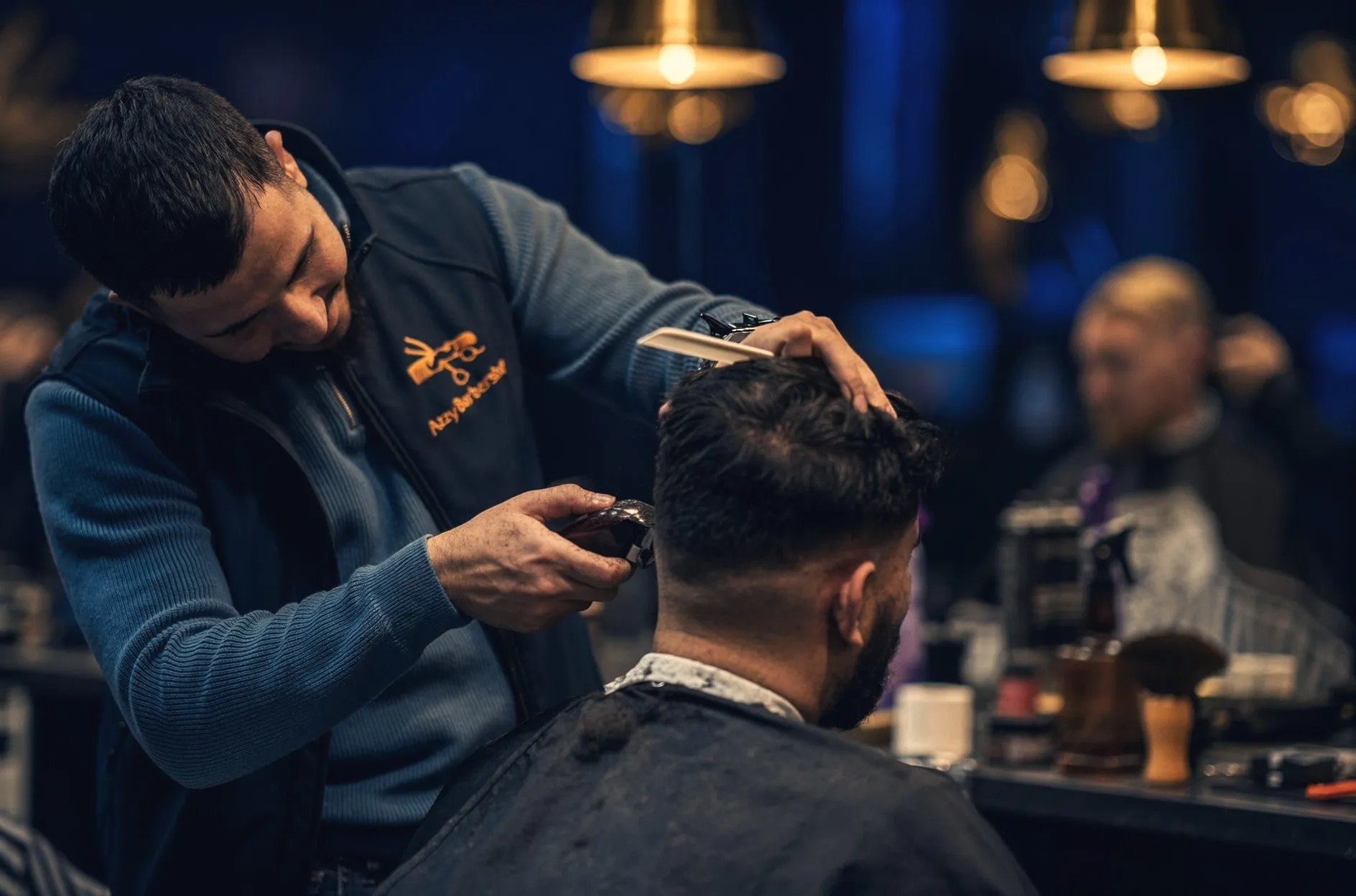 Barberare klipper en fade med maskin på Azzy Barbershop